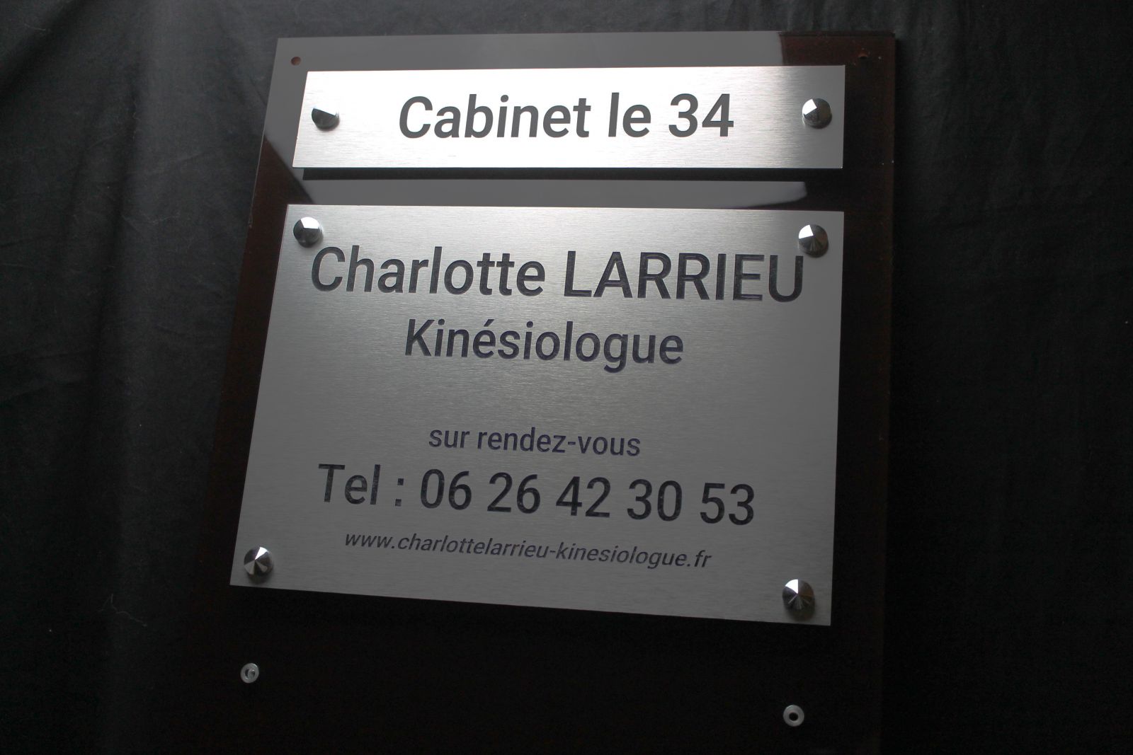Une multi-plaques professionnelles en plexiglas avec des plaques en aluminium d'un cabinet de kiné Larrieu