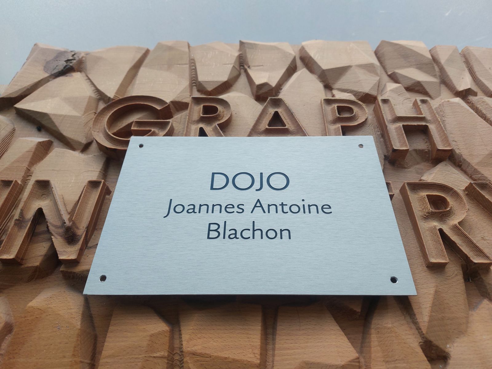 Plaque en aluminium brossée avec gravure et peinture noir pour un dojo