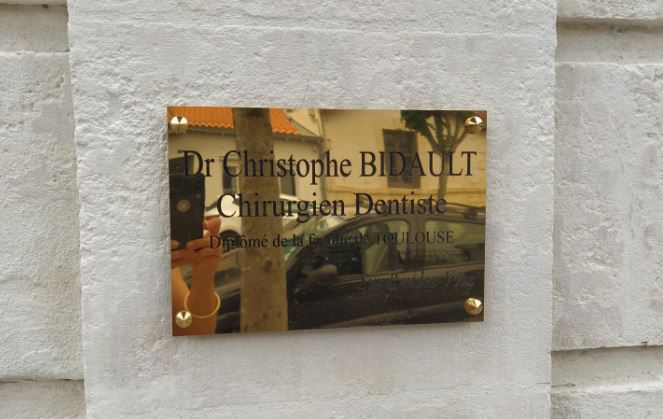 Plaque professionnelle en laiton avec gravure et peinture noire pour un dentiste.